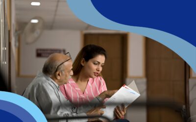 A woman and an elderly man seated together in a hospital room, reading health insurance plans